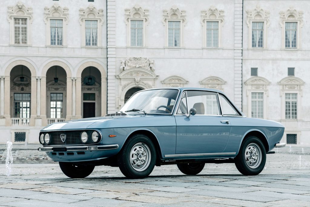 un Lancia Fulvia Coupé delante de un palacio