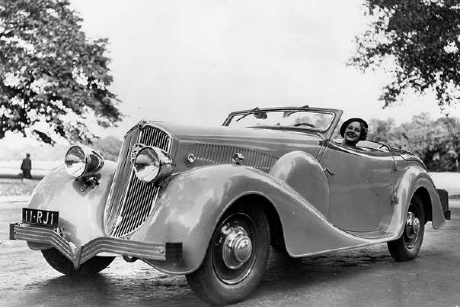 una mujer al volante de un Peugeot 402 descapotable