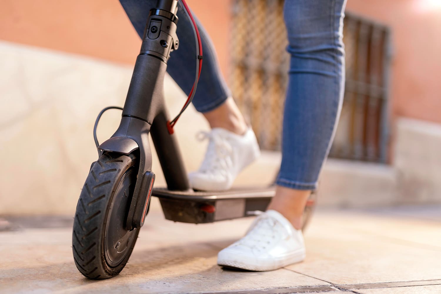 los pies de una mujer en patinete eléctrico