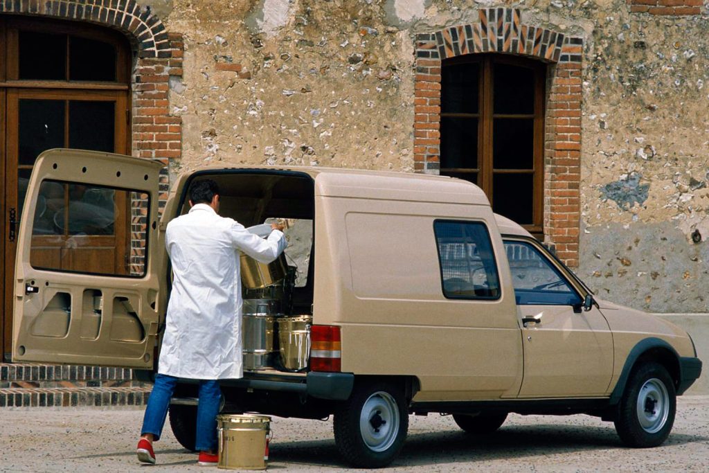 un hombre carga leche en una Citroën C15 de color marrón