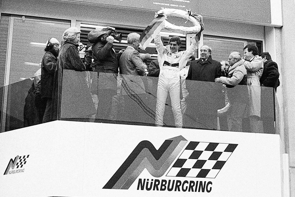 Ayrton Senna celebra su victoria en la carrera de campeones en el podio de Nürburgring en 1984