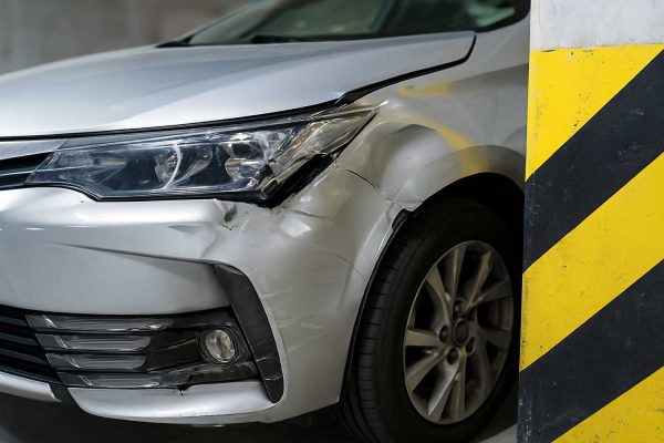 un coche golpeado junto a la columna de un parking