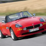 un hombre conduce un BMW Z8 de color rojo