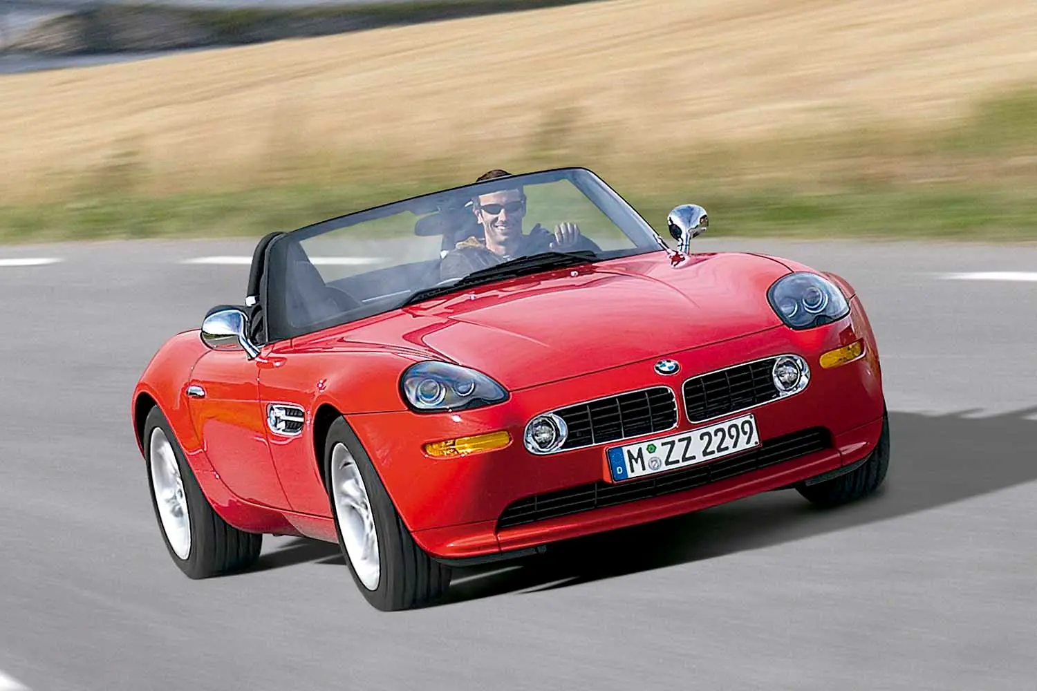 un hombre conduce un BMW Z8 de color rojo