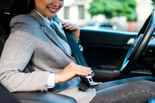 una mujer se dispone a ponerse el cinturón de seguridad en el coche