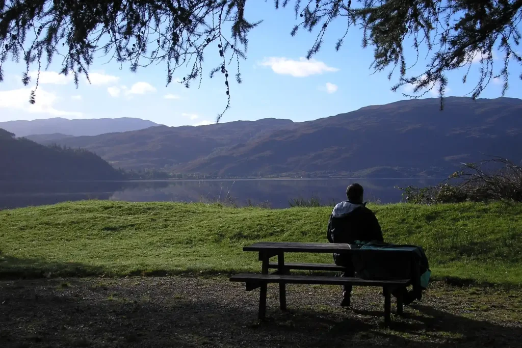 un hombre junto al lago de Lochcarron, en las Highlands de Escocia