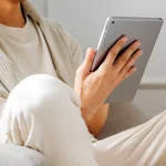 un hombre sostiene una tablet con su mano derecha