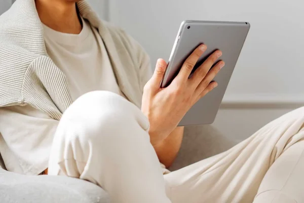 un hombre sostiene una tablet con su mano derecha